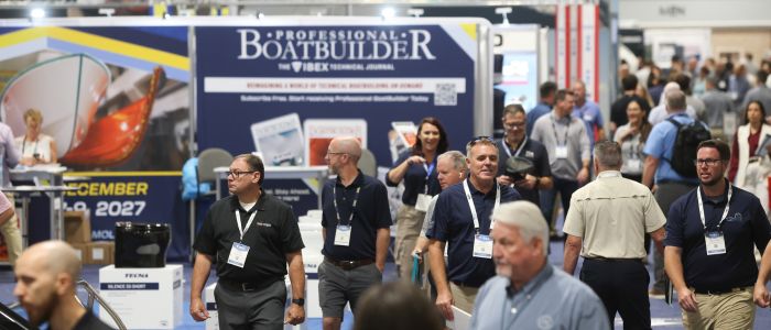 Crowds navigate a busy exhibition hall, with various booths displaying marine products and attendees engaging with one another.